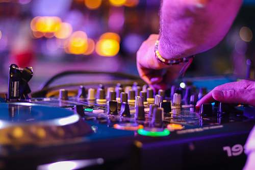 bar counter DJ controlling turntable at night pub